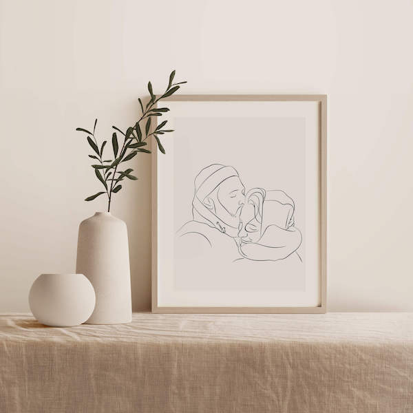 Line Art drawing of a couple, drawing is in a frame on a table next to a plant